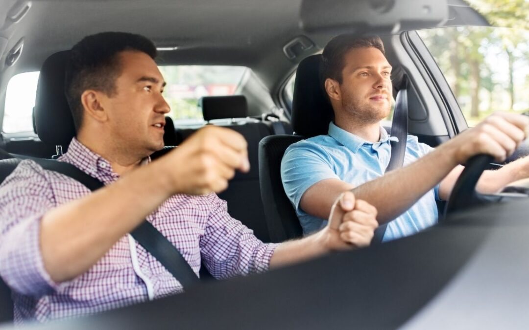 Driving instructor coaching a student during an in-car lesson
